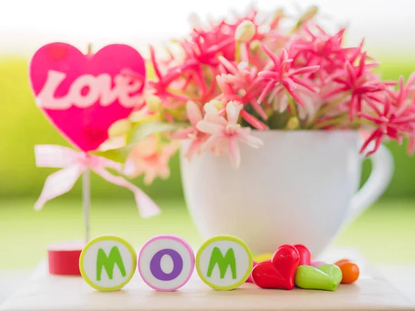 mother's day concept.  LOVE MOM alphabet with colorful heart and flower on background