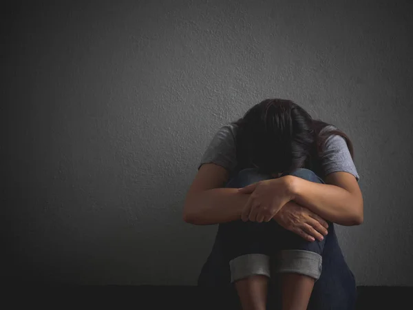 Mulher triste abraçar o joelho e chorar. Mulher triste sentada sozinha em um quarto vazio . — Fotografia de Stock