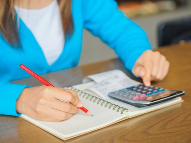 hesap makinesi ile çalışmaya kadın iş belge ve dizüstü bilgisayar dizüstü bilgisayarı