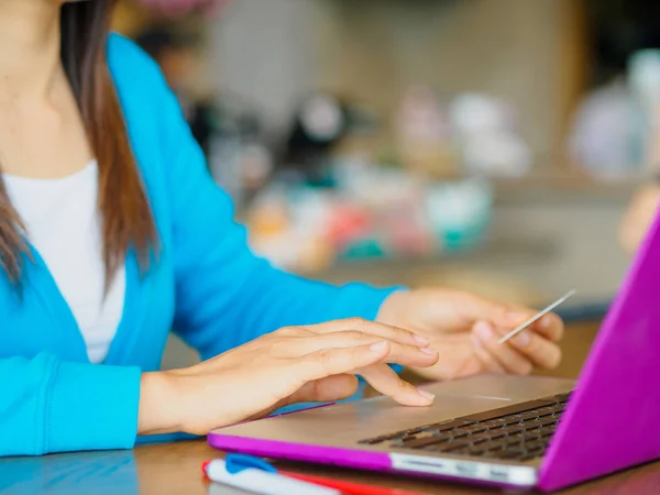 Dość młoda womans ręce trzyma karty kredytowej i przy użyciu komputera przenośnego na zakupy online. — Zdjęcie stockowe