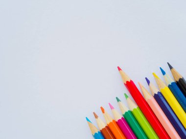 Beyaz kağıt üzerine renkli kalemler. Eğitim malzeme geri için okula, arka plan ve duvar kağıdı.