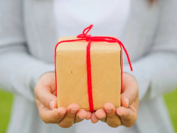 Mani che tengono bella scatola regalo, femminile dando regalo, vacanze di Natale e concetto di stagione di saluto, — Foto Stock