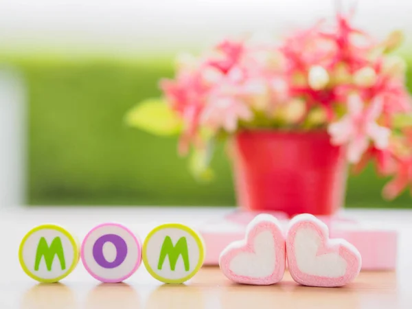 Mother's day concept. MOM alphabet with marshmallow in the shape of heart and flower on background — Stock Photo, Image