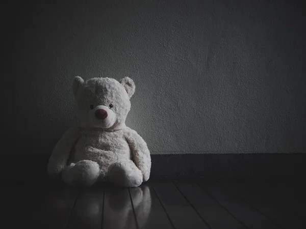 Одинокий медведь Тедди, сидящий в темной комнате (о любви ) — стоковое фото