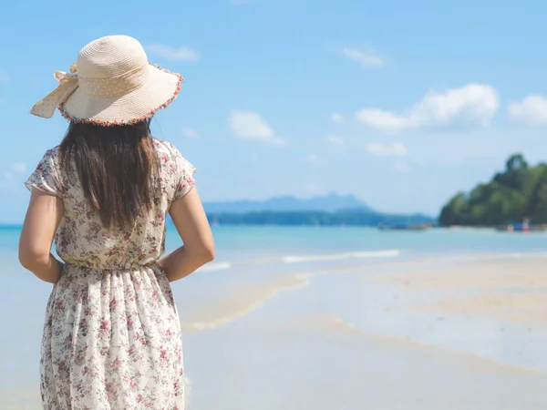 Mujer en vacaciones de verano con sombrero de paja y vestido de playa disfrutando de la vista al mar — Foto de Stock