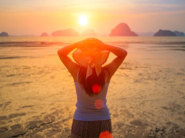 Kadın şapkası güneşin altında Kollarını açarak denize yakın