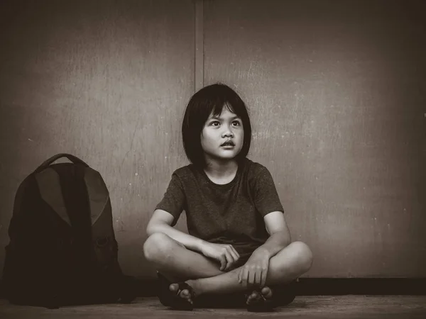 Retro picture with grain. Sad Kid sitting on the floor with school bag waiting for parent. — Stock Photo, Image