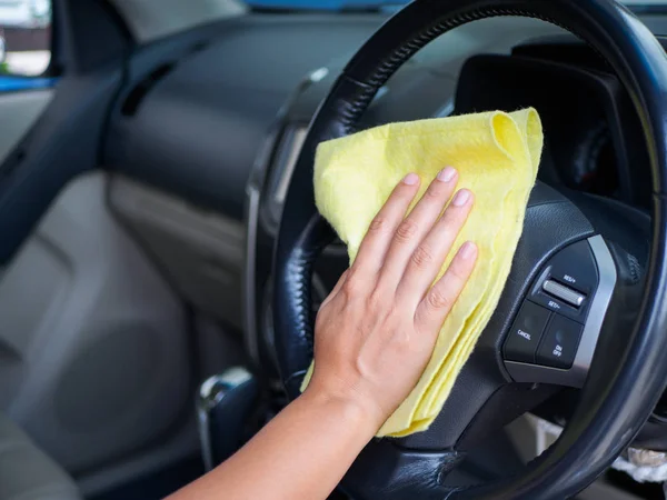 Hand cleaning interior car steering wheel with microfiber cloth