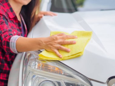 Sarı mikrofiber temizlik bezi ile beyaz el Otomobil.