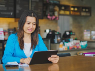 Genç ve güzel kadının tutarak ve online alışveriş, fatura, kalem ve hesap tablosundaki tablet kullanarak eller.