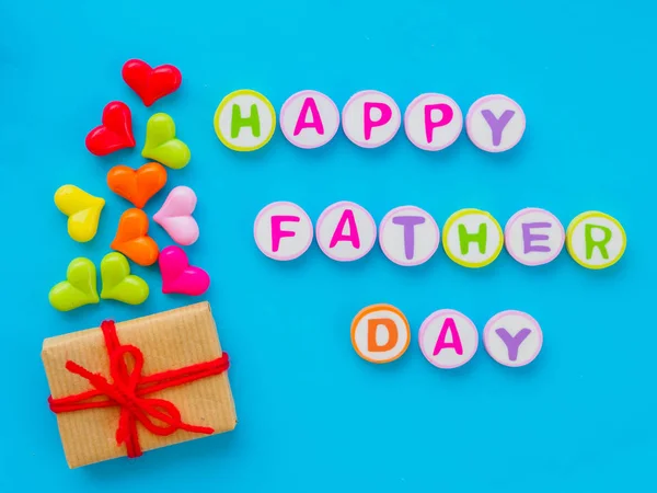 Concepto del día del padre. FELIZ PADRE alfabeto DÍA con corazón colorido y regalo sobre fondo azul — Foto de Stock