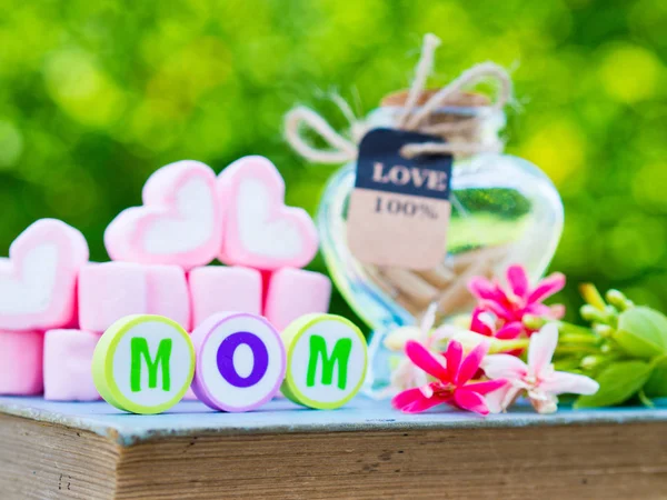 Mother's day concept. MOM alphabet with marshmallow in the shape of heart and flower on background — Stock Photo, Image