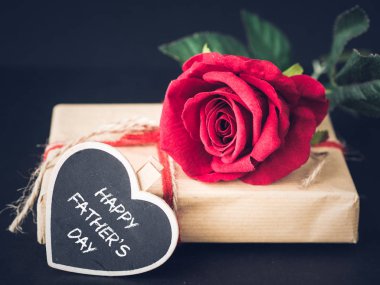 Babalar günü kavramı. Siyah zemin üzerine kırmızı gül ile mutlu Babalar günü mesajı