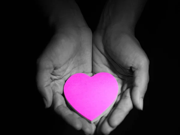 Ροζ καρδιά σε γυναίκα χέρια, χαμηλών τόνων εικόνα ύφος, σκοτεινό και μαύρο φόντο. έννοια της αγάπης. — Φωτογραφία Αρχείου
