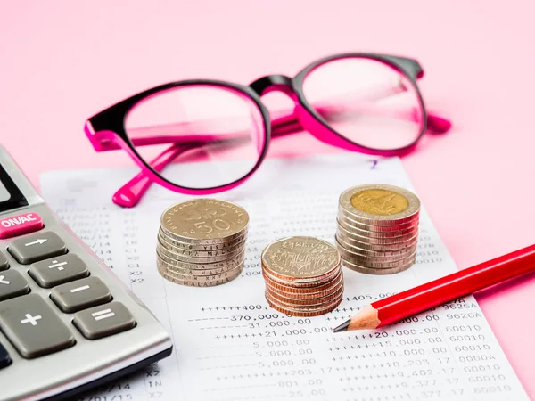 Ahorro de dinero abstracto. estado financiero con pila de monedas, calculadora, vasos y lápiz sobre fondo rosa . — Foto de Stock