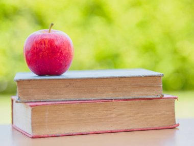 Dünya kitap günü kavramı. Kırmızı elma ve eski kitaplar yığında koymak kalem