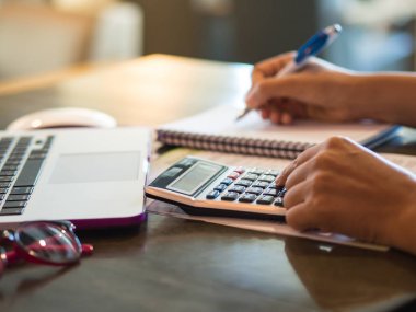 hesap makinesi ile çalışmaya kadın iş belge ve dizüstü bilgisayar dizüstü bilgisayarı