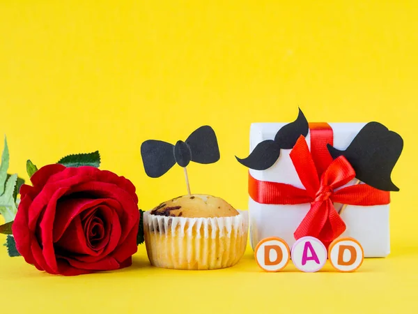 Concepto del día del padre. Mensaje DAD con rosa roja y regalo sobre fondo amarillo — Foto de Stock