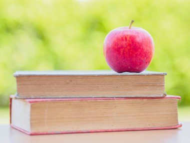 Dünya kitap günü kavramı. Kırmızı elma ve eski kitaplar yığında koymak kalem