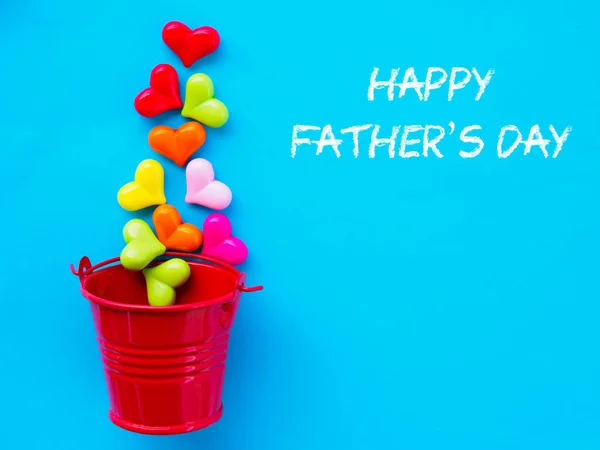 Concepto del día del padre. FELIZ DÍA DEL PADRE texto con corazón colorido y regalo sobre fondo azul — Foto de Stock