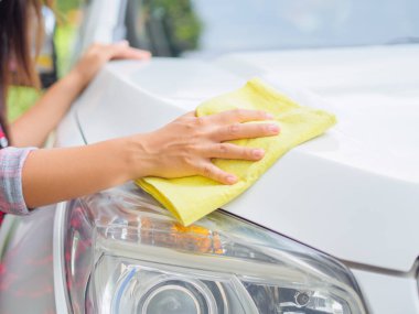 Sarı mikrofiber temizlik bezi ile beyaz el Otomobil.