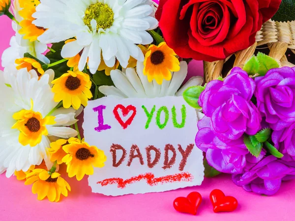 Concepto del día del padre. TE AMO Mensaje de papá con flor blanca y amarilla, dos corazones rojos y bigote negro sobre fondo rosa — Foto de Stock