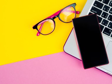 Smartphone üstten görünüm dizüstü, fare, gözlük ve pembe, sarı ve yeşil ve Sarı zemin üzerine kalem