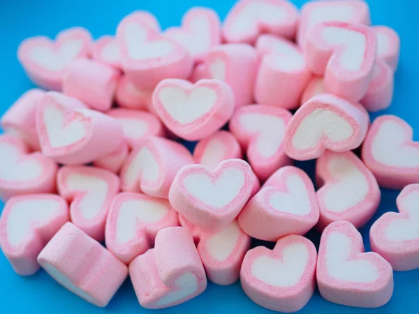 Close-up van zoete marshmallow in de vorm van hart op blauwe achtergrond. Begrip over liefde en relatie. (Zachte stijl voor achtergrond) — Stockfoto