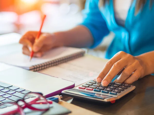 Mulher trabalhando com calculadora, documento de negócios e notebook de computador portátil — Fotografia de Stock