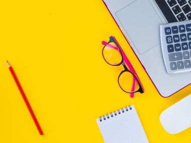hesap makinesi, fare dizüstü, gözlük, kırmızı kalem ve Sarı zemin üzerine Not Defteri gibi ofis aksesuarları. Eğitim ve iş kavramı.
