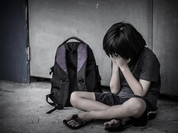 Retro picture with grain. Sad Kid sitting on the floor with school bag waiting for parent. — Stock Photo, Image