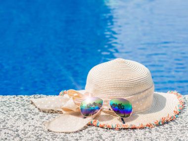 Güzel yaz şapka ve güneş gözlüğü havuz kenarındaki. Tatil, plaj, yaz seyahat kavramı