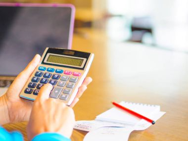 hesap makinesi ile çalışmaya kadın iş belge ve dizüstü bilgisayar dizüstü bilgisayarı