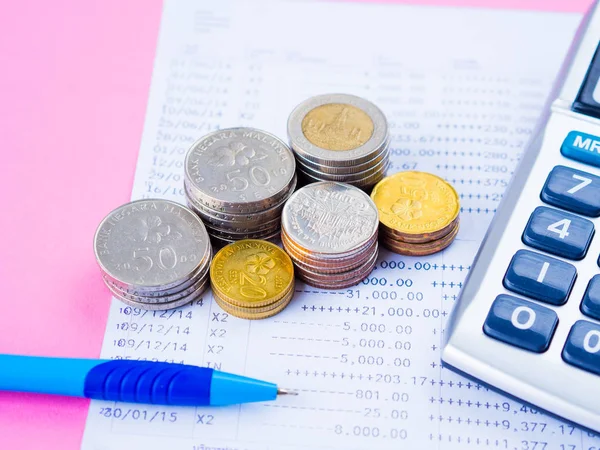Ahorro de dinero abstracto. estado financiero con pila de monedas, calculadora y pluma azul sobre fondo rosa . — Foto de Stock