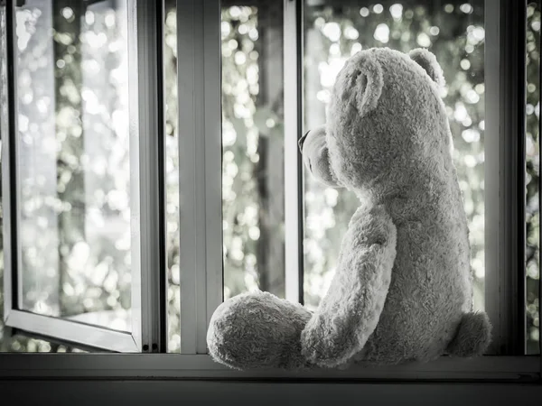 Eenzame teddybeer zittend op het venster uitkijken kant (Concept over liefde) — Stockfoto