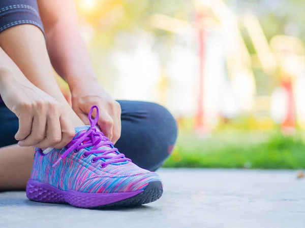 Τρέχοντας παπούτσια - closeup της γυναίκας δένοντας Κορδόνια παπουτσιών. Γυναικεία Αθλητικά γυμναστήριο δρομέας ετοιμάζεται για τρέξιμο με εξοπλισμό γυμναστηρίου στο παρασκήνιο — Φωτογραφία Αρχείου