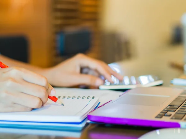 Женщина, работающая с калькулятором, бизнес-документом и ноутбуком — стоковое фото