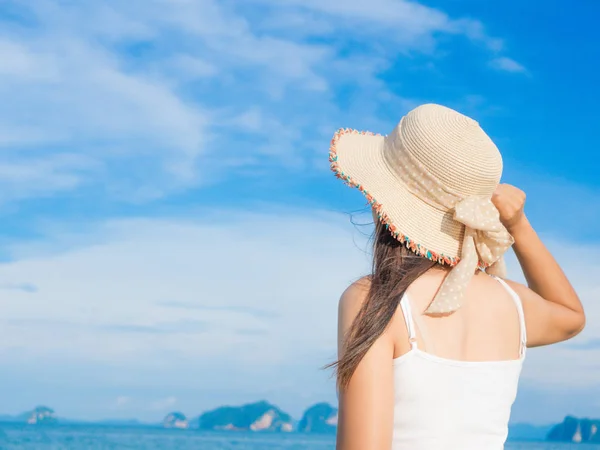 Mujer en vacaciones de verano con sombrero de verano y vestido de playa mirando la hermosa vista al mar — Foto de Stock