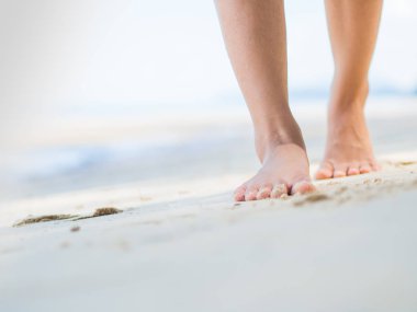 Plaj seyahat - kum plajı üzerinde yürüyen kadın. Kadın ayak detay. Kavram adım.