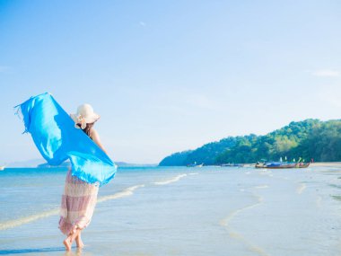 Kadın yaz tatil giyen yaz şapka ve plaj elbise Okyanusu güzel manzaraya bakarak