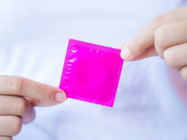 Prezervatif, seks kavramı kaydetmek seçici odak tutan el.