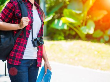 Harita yol ve orman arka plan, tatil kavramı seyahat, vintage sesi ve yumuşak odak rengini Relax zamanında sırt çantası ile tutarak mutlu Asyalı kız