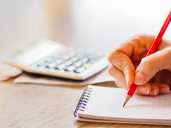 Mujer usando calculadora y pensando en el costo en el escritorio en la oficina en casa . —  Fotos de Stock