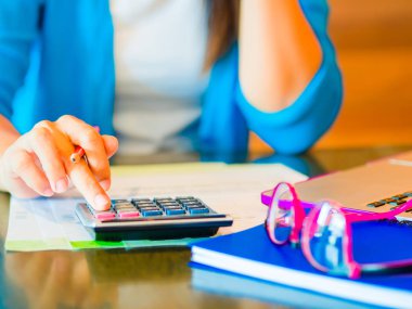 hesap makinesi ile çalışmaya kadın iş belge ve dizüstü bilgisayar dizüstü bilgisayarı