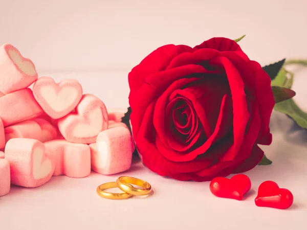 Rosa rossa romantica con anelli d'oro e cuori rossi su sfondo bianco. Amore, proposta, giorno di San Valentino e vacanze concetto . — Foto Stock