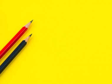 Ofis aksesuarları, Sarı zemin üzerine kırmızı ve siyah kalem. Eğitim ve iş kavramı.