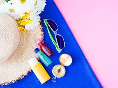 Yaz şapka, Güneş Losyonu, şampuan ve çiçek pembe bir arka plan üzerinde güneş gözlüğü. Tatil ve dinlenme, yaz seyahat kavramı.