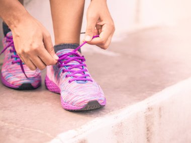 Retro kadın ayakkabı bağcıklarımı bağlıyor. Tatlı kadın spor fitness Runner açık koşu için hazırlanıyor. Fitness ve spor kavramı.