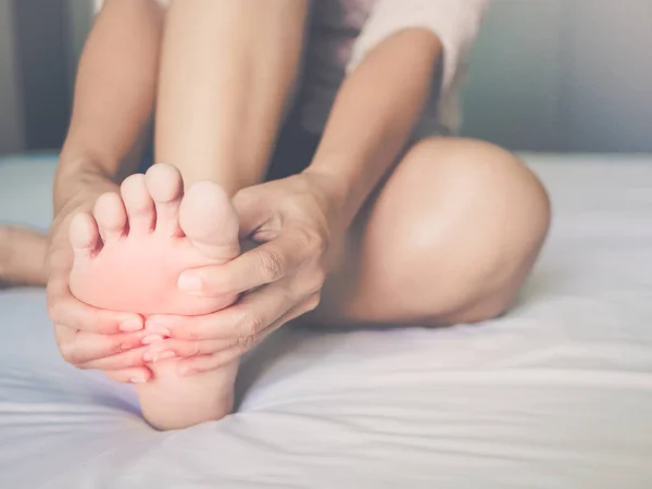 Concepto de atención médica. mujer masajeando su doloroso pie, rojo hi-lit en la zona del dolor — Foto de Stock