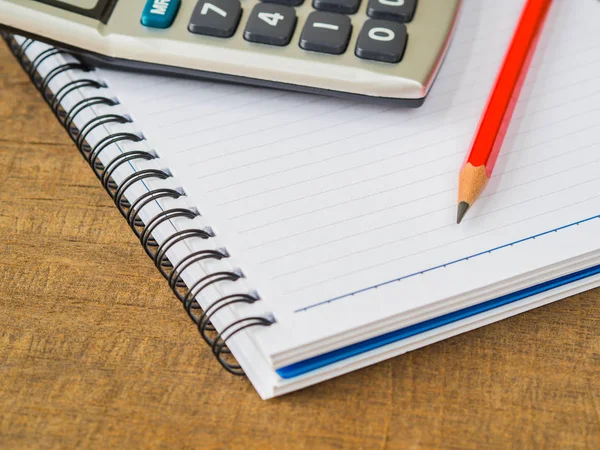 Office tillbehör inklusive notera bokar, röd penna och kalkylator på trä bakgrund. Utbildning och affärsidé. — Stockfoto